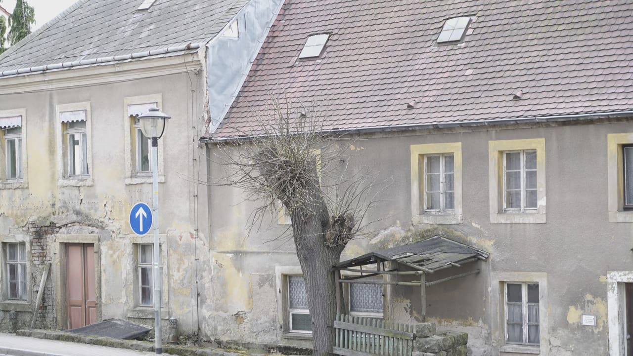 Verwitterte Straßenfassade des alten Wirts- und Kolonialwarenhauses in Pesterwitz mit abblätterndem Putz